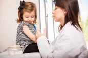 Pediatra administrando vacuna a niña