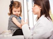 Pediatra administrando vacuna a niña