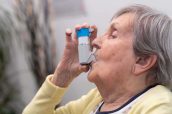 Old woman using an asthma inhaler