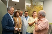El consejero Gómez Caamaño, junto a profesionales y autoridades, observa la inoculación de la vacuna en un paciente.