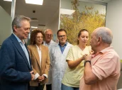 El consejero Gómez Caamaño, junto a profesionales y autoridades, observa la inoculación de la vacuna en un paciente.
