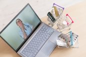 Online medicine and pharmacy concept. A female doctor conducts an online consultation and recommends medications. Mini trolley with tablets at the laptop