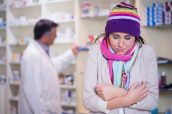 Sick woman with scarf and colorful hat in the pharmacy
