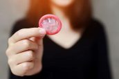 Condom ready to use in female hand, give condom safe sex concept