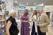 La delegada de Servicios Sociales y Mayores del Ayuntamiento, Eva Contador; y el presidente del Colegio de Farmacéuticos de Córdoba, Rafael Casaño, hablando con una persona mayor en la farmacia de la Plaza de Colón, durante la presentación de la iniciativa.