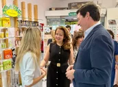 La consejera, Fátima Matute y el presidente del COFM, Manuel Martínez del Peral, conversan con una farmacéutica durante la presentación de la iniciativa.